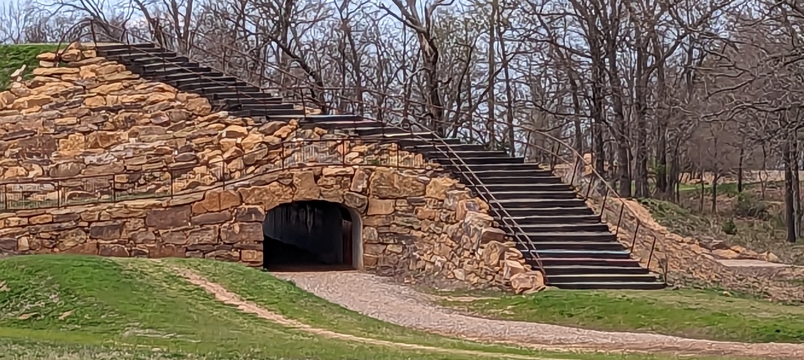 Bike trail featuring stairs running over a giant tunnel that is also part of the trail.