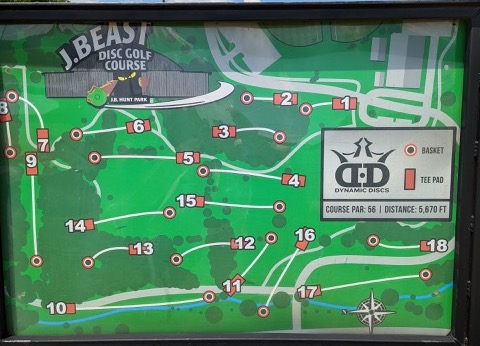 The sign posted at the start of the J Beast disc golf that's located at JB Hunt Park. It has a map of each hole listed along with red lines indicating the path of each hole.